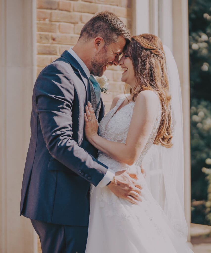 Bride and groom posing together on their wedding day at De Courceys Manor, surrounded by the scenic countryside backdrop.