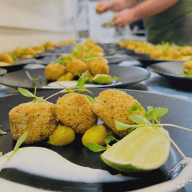 Fishcake Starter with Bombay Potatoes on a black gourmet dish