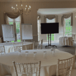 Cabaret style conferencing setup with flip charts and TV presentation