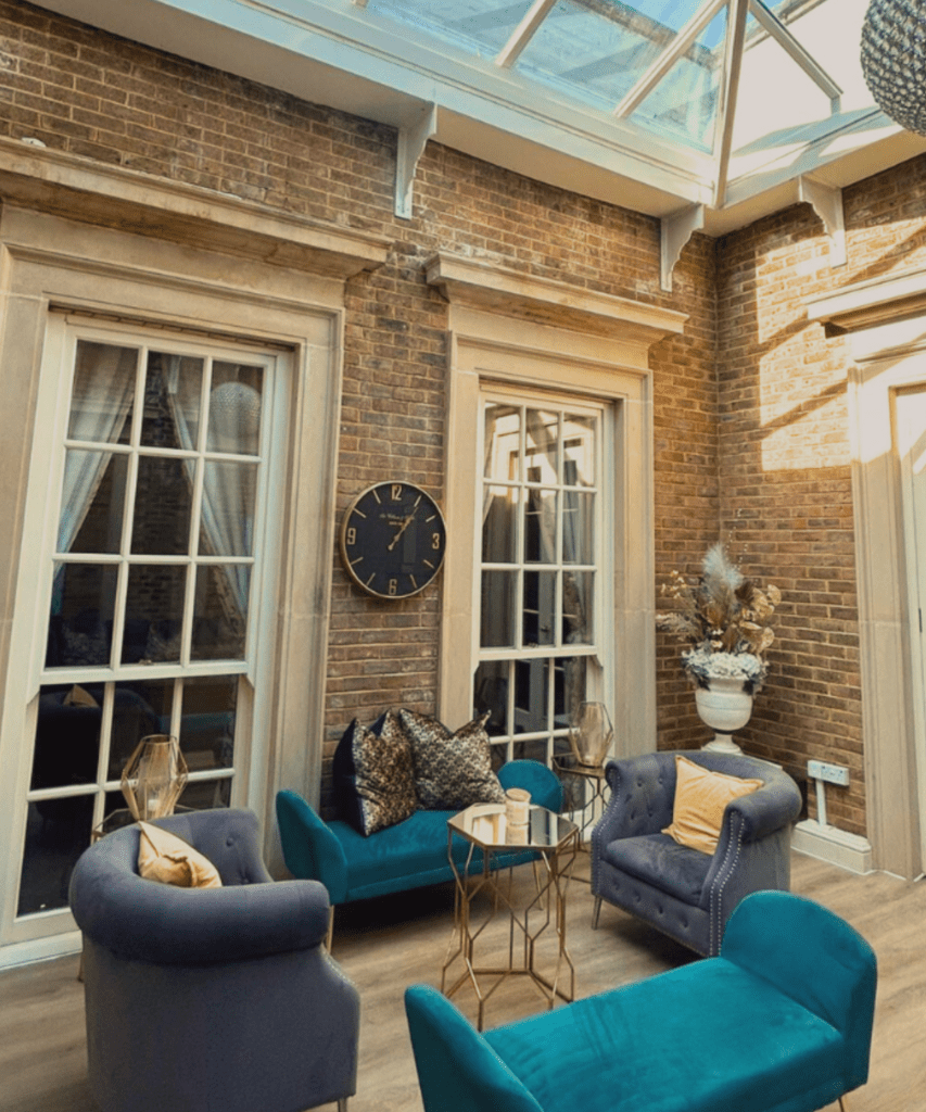 Elegant internal room at De Courceys Manor featuring a stunning glass-ceiling atrium, allowing natural light to flood the stylish space.